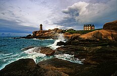 Haus u. Leuchtturm mit spritzender Gischt